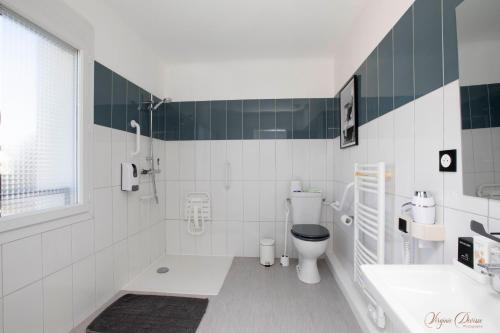 a white bathroom with a toilet and a sink at L Escale in Ports