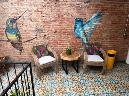 a mural of three birds on a brick wall at Casa en tlaquepaque in Guadalajara