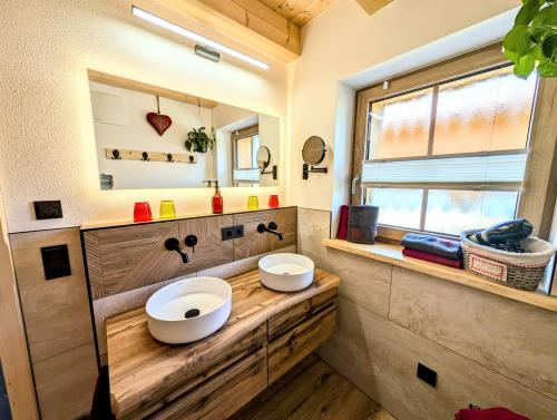 a bathroom with two sinks on a wooden counter at Inser Hof - Hüttenleben Bayern in Mauth