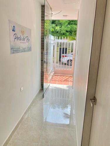 a hallway with a glass door leading to a patio at Perla del río habitaciones in Barranquilla