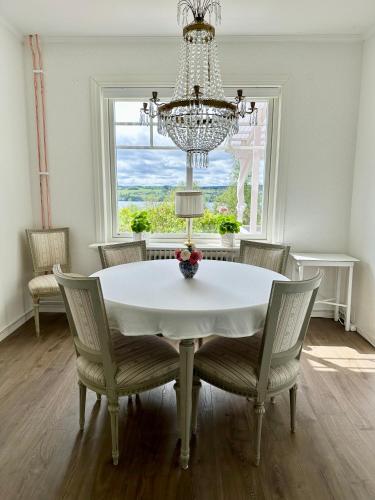 a dining room with a table and chairs and a chandelier at Sörbygården Bed & Breakfast in Brunflo