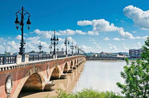 a bridge over a river with street lights on it at Gîte au calme entre Saint Emilion et Bordeaux in Lugon et l’Ile du Carney