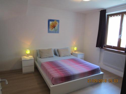 a bedroom with a bed with two night stands and two lamps at Appartamento Emma in Faver