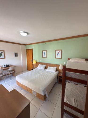 Un dormitorio grande con dos camas y una mesa. en Golden dolphin Grand hotel, en Caldas Novas