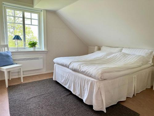 a white bed in a room with a window at Sörbygården Bed & Breakfast in Brunflo