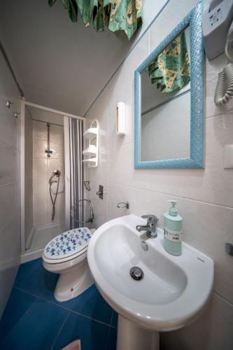 a bathroom with a sink and a toilet and a mirror at The twins Rooms in Trapani 1 in Trapani