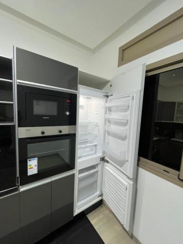 a kitchen with an open refrigerator and a microwave at Najla Sh4 in Tangier