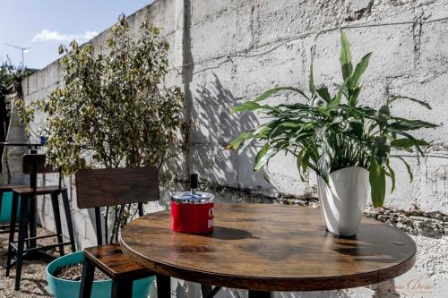 a wooden table with a vase and plants on a patio at L Escale in Ports