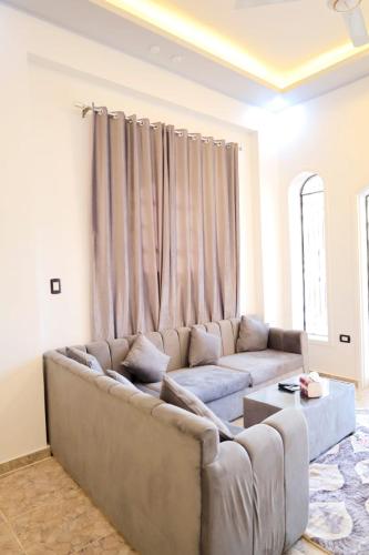 a living room with a couch and a curtain at Tomorrow Land villa in Luxor