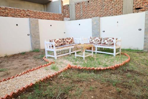 two chairs and a table in a yard at Tomorrow Land villa in Luxor