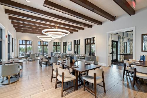 a dining room with tables and chairs and windows at 2147 Cooper Bell in Kissimmee