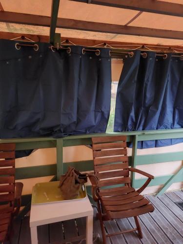 une chambre avec une table, deux chaises et un rideau dans l'établissement Charmant mobilhome au camping La Lande, à Mimizan