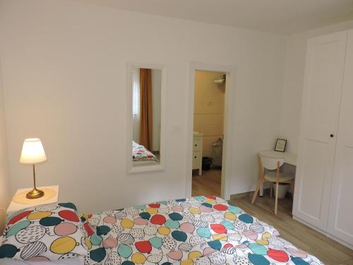 a bedroom with a bed and a lamp and a mirror at Apartments Villa Elma in Mošćenička Draga