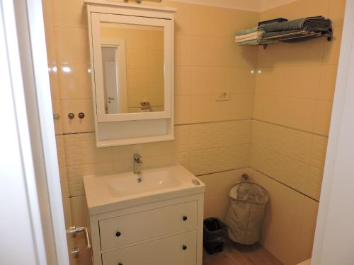a bathroom with a sink and a mirror at Apartments Villa Elma in Mošćenička Draga