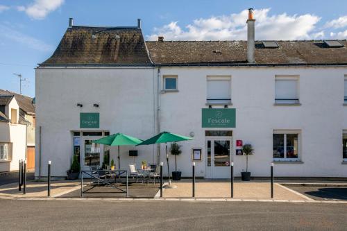a white building with green umbrellas in front of it at L Escale in Ports