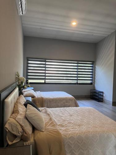a bedroom with two beds and a large window at Rancho Florean in Montemorelos