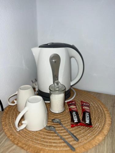 einen Tisch mit einer Teekanne und Tassen darauf in der Unterkunft Helios Rooms in Sarandë