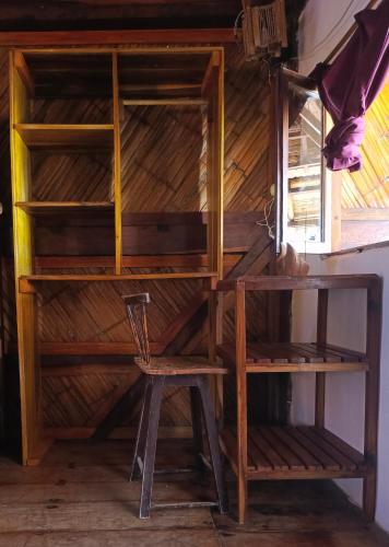a room with a wooden shelf and a chair at Hostal Mirada al Mar in Las Tunas