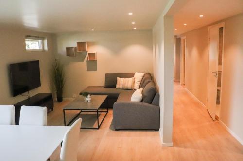 a living room with a couch and a table at New apartment close to Preikestolen in Strand