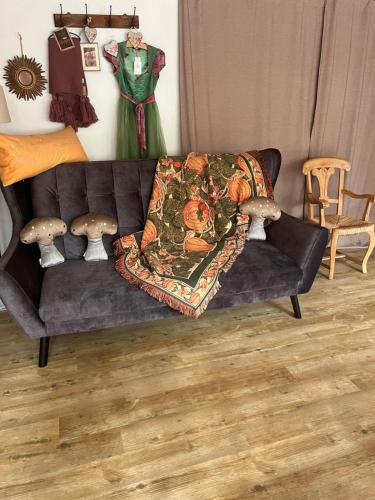 a black couch with a blanket on it in a living room at B&B Apart Hotel Goldener Hahn - Hygge Pool & Sauna in Baiersbronn