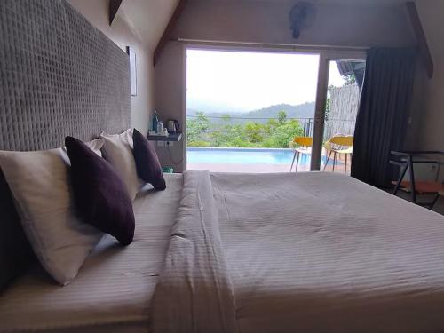 a bedroom with a large bed with a view of a pool at Kap Korome Village Resort in Koroth