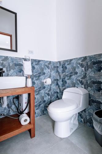 a bathroom with a toilet and a sink at Wide Mouth Frog Quepos in Manuel Antonio