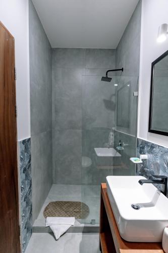 a bathroom with a shower and a sink and a tub at Wide Mouth Frog Quepos in Manuel Antonio