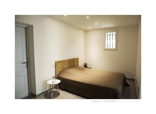 - une chambre avec un lit et une petite table dans l'établissement villa méditerranée, à Puissalicon