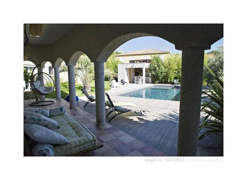 un patio avec une piscine et une maison dans l'établissement villa méditerranée, à Puissalicon