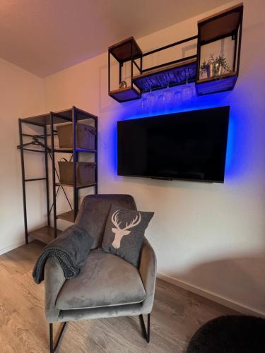 a living room with a chair and a flat screen tv at Exklusive FeWo AllgäuStern Steibis mit WLAN Sauna Kamin und Oberstaufen PLUS Card mit SKIPASS in Oberstaufen