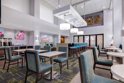 a dining room with tables and chairs and a bar at Hampton Inn & Suites Shreveport in Shreveport
