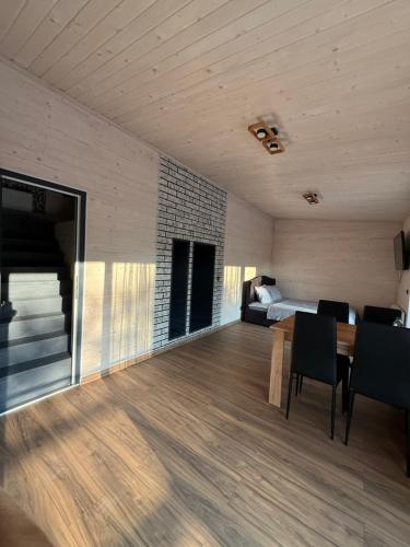 ein Wohnzimmer mit einem Tisch und einem Bett in einem Zimmer in der Unterkunft Садиба-Сойми in Mischhirja