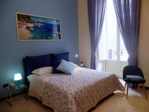 - une chambre avec un lit aux murs bleus et une fenêtre dans l'établissement B&B La Canzanella, à Naples