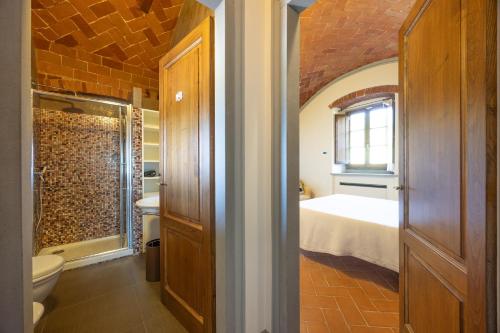 Un baño con una cama y un inodoro en una habitación. en Villa Casaforte, en Loro Ciuffenna
