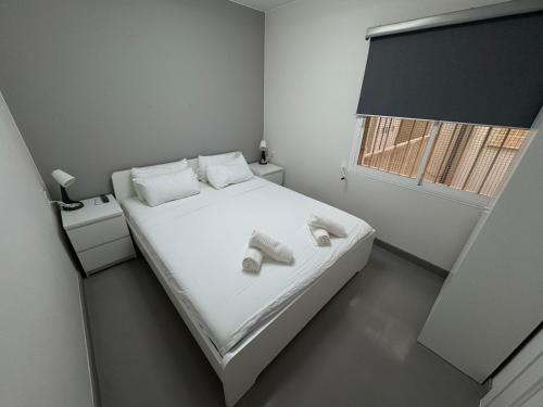 a bedroom with a bed with white shoes on it at Apartamentos en la rambla in Sant Feliu de Guixols