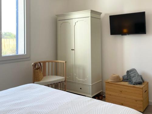 a bedroom with a bed and a cabinet and a tv at Villa SalSea in Marausa