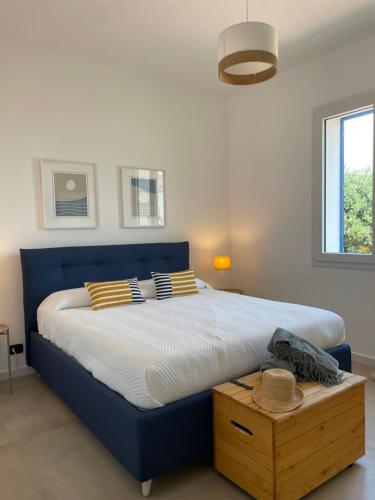 a blue bed with striped pillows on it in a bedroom at Villa SalSea in Marausa