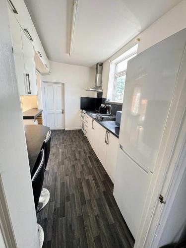 a kitchen with a white refrigerator and a sink at Bright & Cozy Private Room Near Bristol City Centre in Bristol