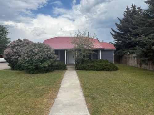 a house with a red roof and a sidewalk at New Listing, Blue Cabin, Downtown, Cozy Getaway in Driggs
