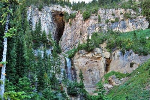 a waterfall on the side of a rocky mountain at New Listing, Blue Cabin, Downtown, Cozy Getaway in Driggs