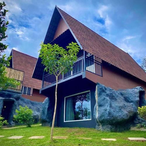 a house with a tree in front of it at Kap Korome Village Resort in Koroth