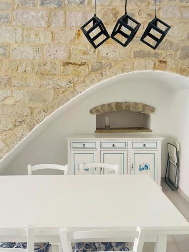 a kitchen with a white table and a stone wall at Suite 125 Carloforte in Carloforte
