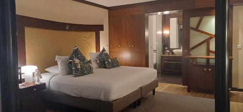 a bedroom with a large bed with pillows on it at Matavai View - Premium Oceanfront Suite in Arue