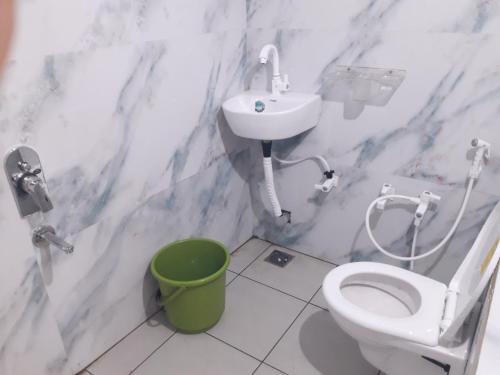 Un baño con un inodoro blanco y un lavabo. en Ashirvad Home Stay ujjain, en Ujjain