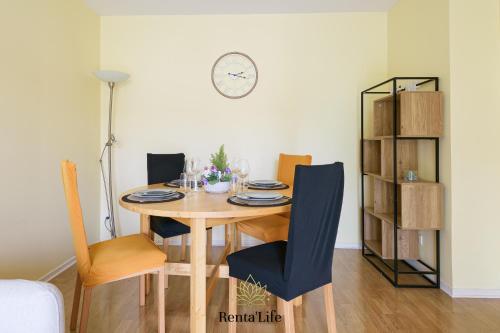 une table à manger avec des chaises et une horloge murale dans l'établissement Buxengeorgiens Giroust - T2 - 10min DisneyLand, à Bussy-Saint-Georges