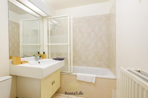 une salle de bain avec un lavabo et une baignoire dans l'établissement Buxengeorgiens Giroust - T2 - 10min DisneyLand, à Bussy-Saint-Georges