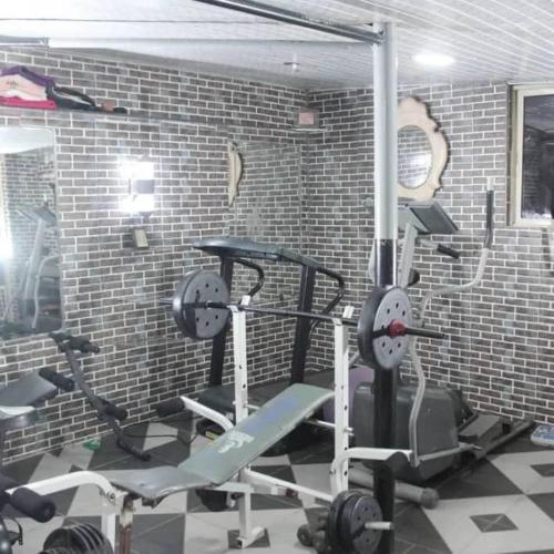 a gym with several exercise bikes in a brick wall at Goldbond Service Apartment in Abeokuta
