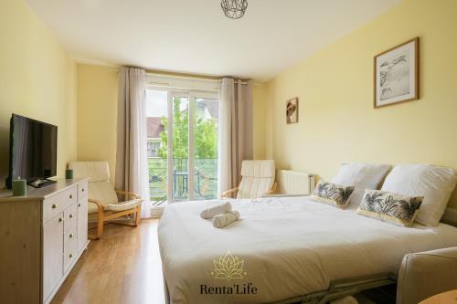 une chambre avec un lit, une télévision et une fenêtre dans l'établissement Buxengeorgiens Giroust - T2 - 10min DisneyLand, à Bussy-Saint-Georges