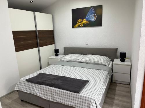 a bedroom with a bed with a butterfly picture on the wall at Âme de la nature in Nedeščina