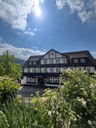 a large building with the sun in the sky at B&B Apart Hotel Goldener Hahn - Hygge Pool & Sauna in Baiersbronn